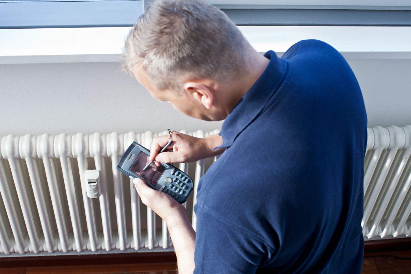 Eficiencia energética en edificios. Técnico midiendo calefacción